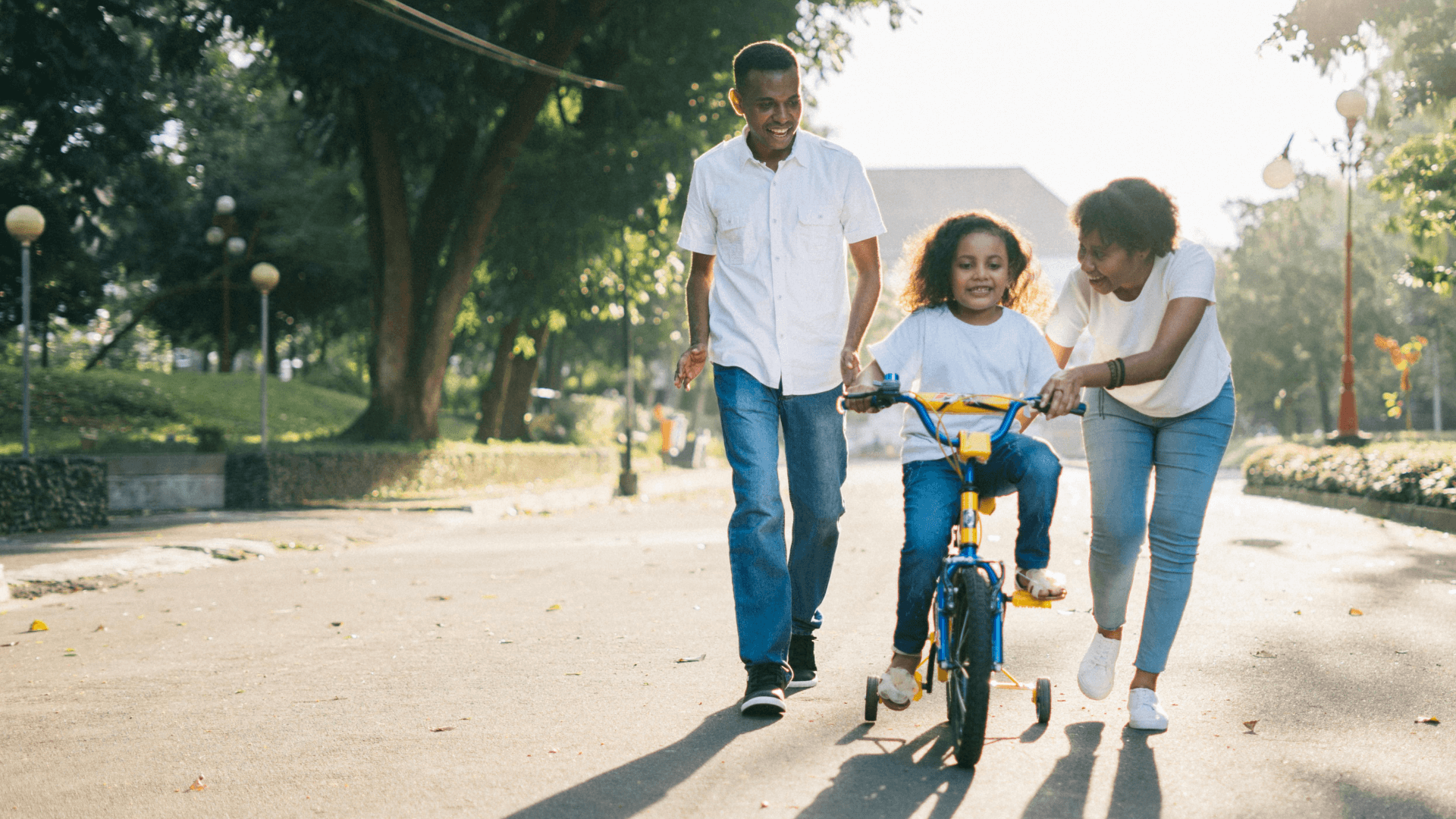 Young family teaching their child to ride a bike