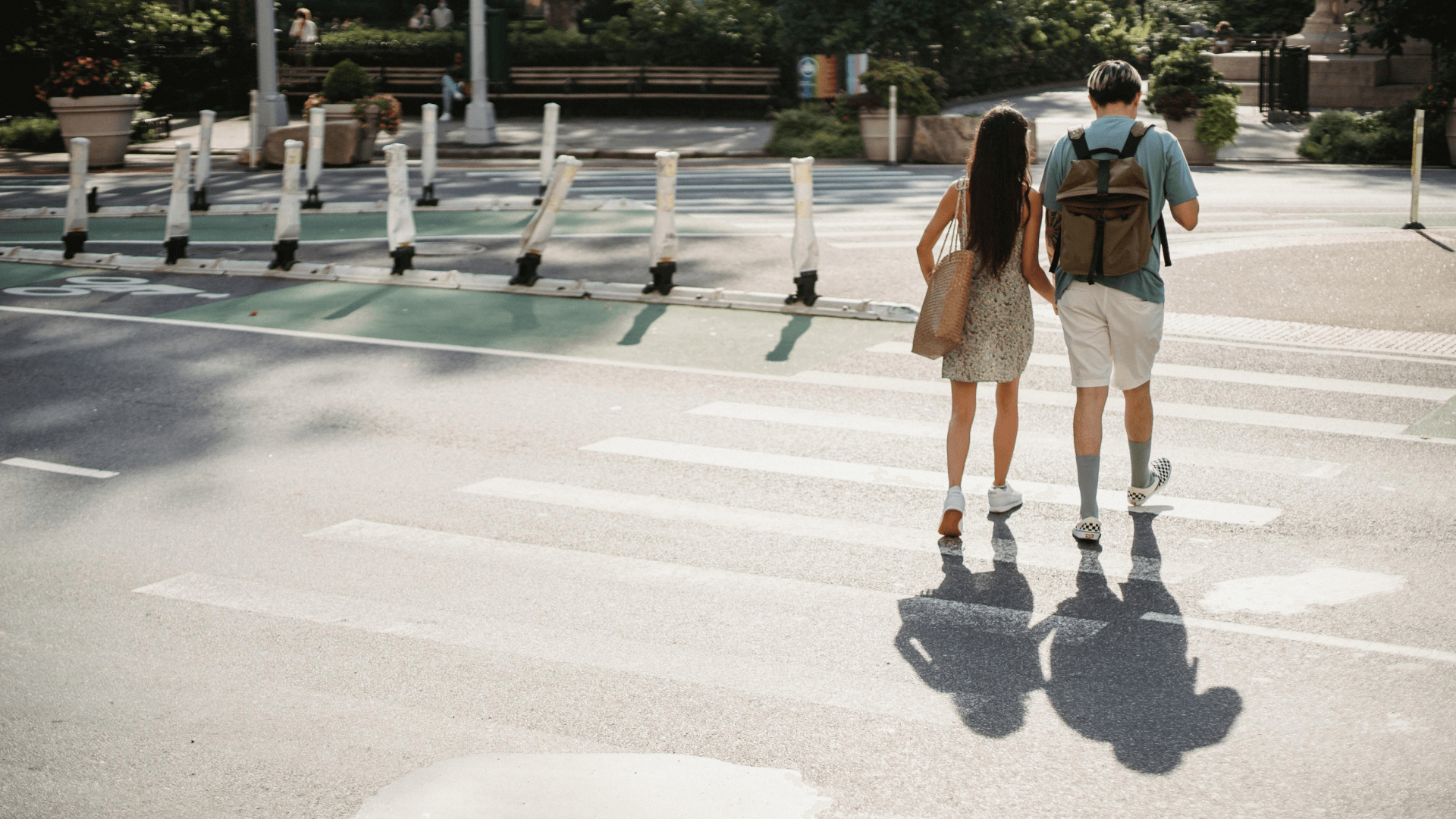 A couple walking across a street on a crosswalk