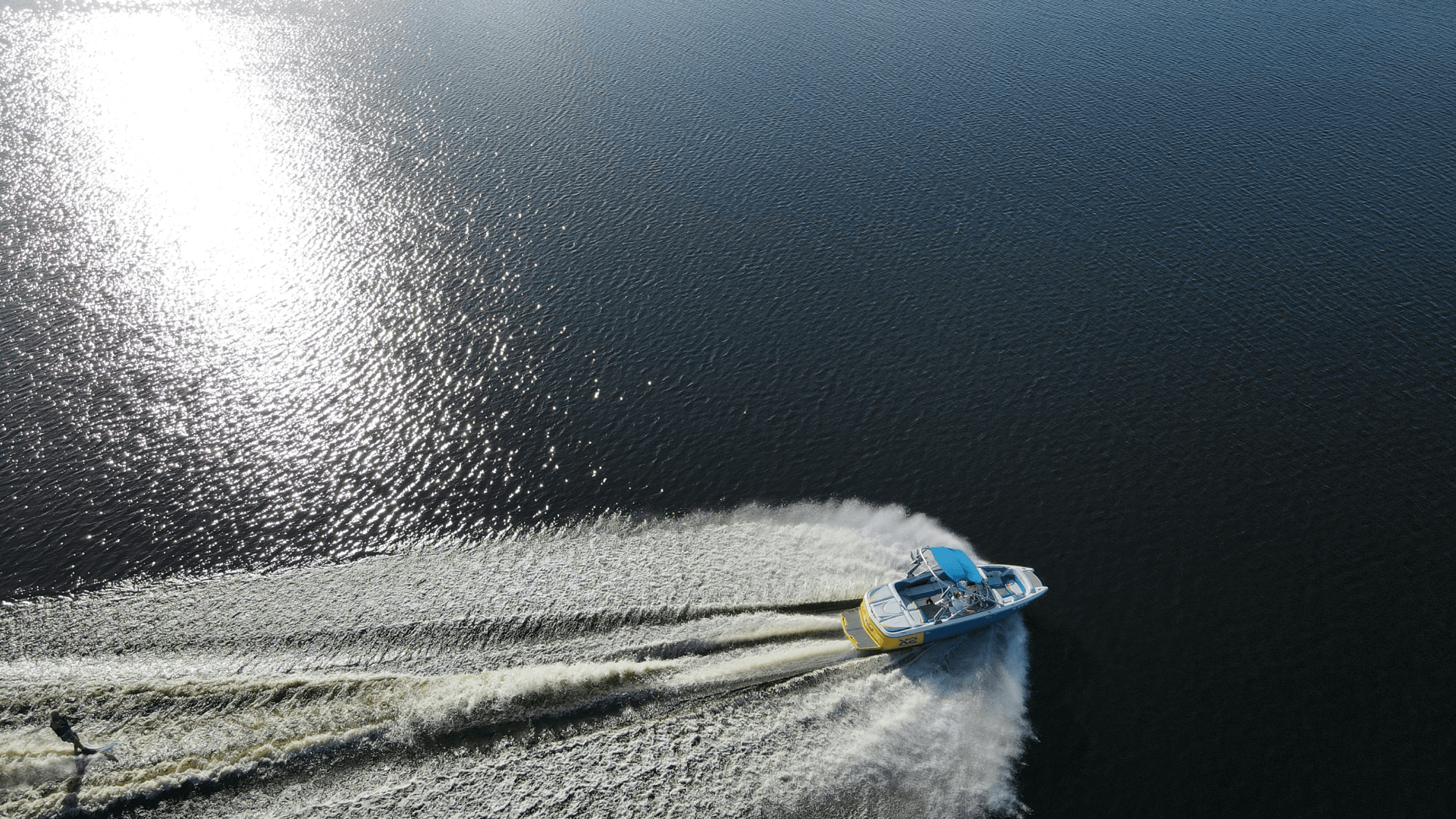 birds eye view of a boat small speed boat traveling across a body of water