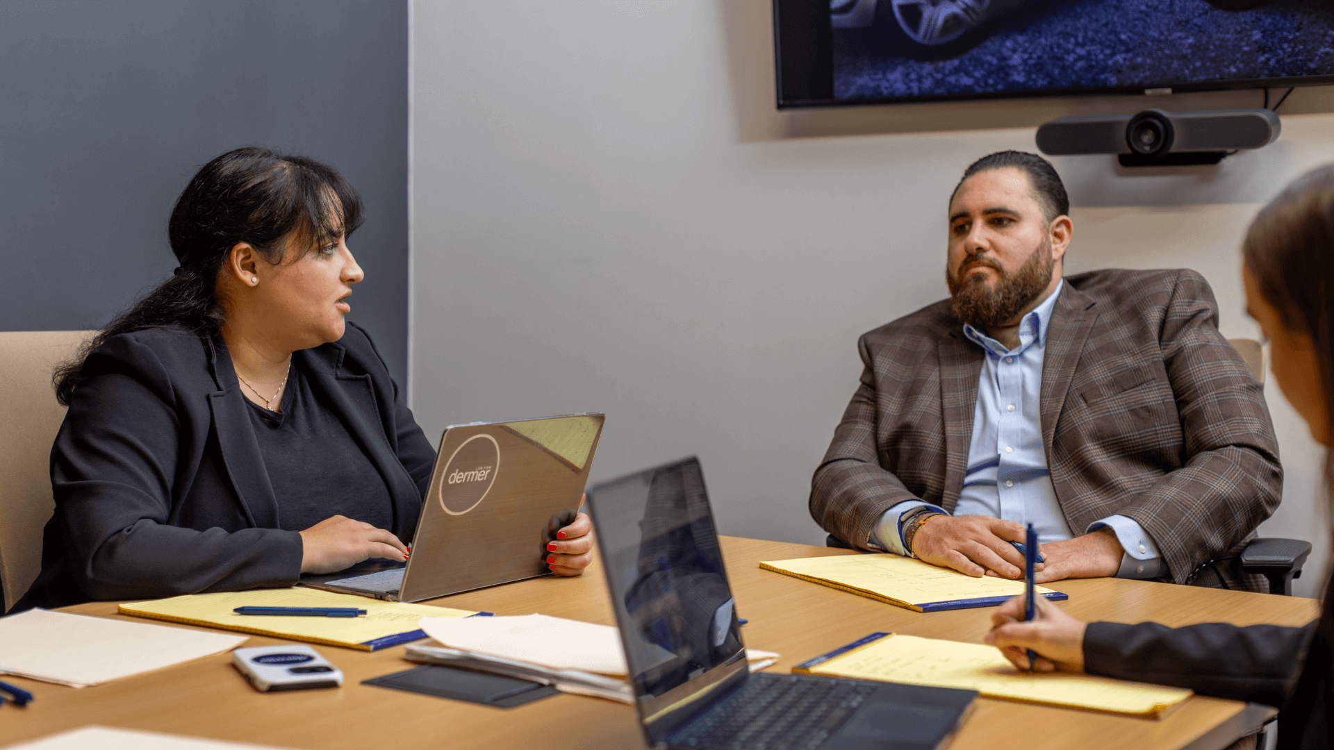 Jay Dermer sitting in a conference room discussing a case with a clients