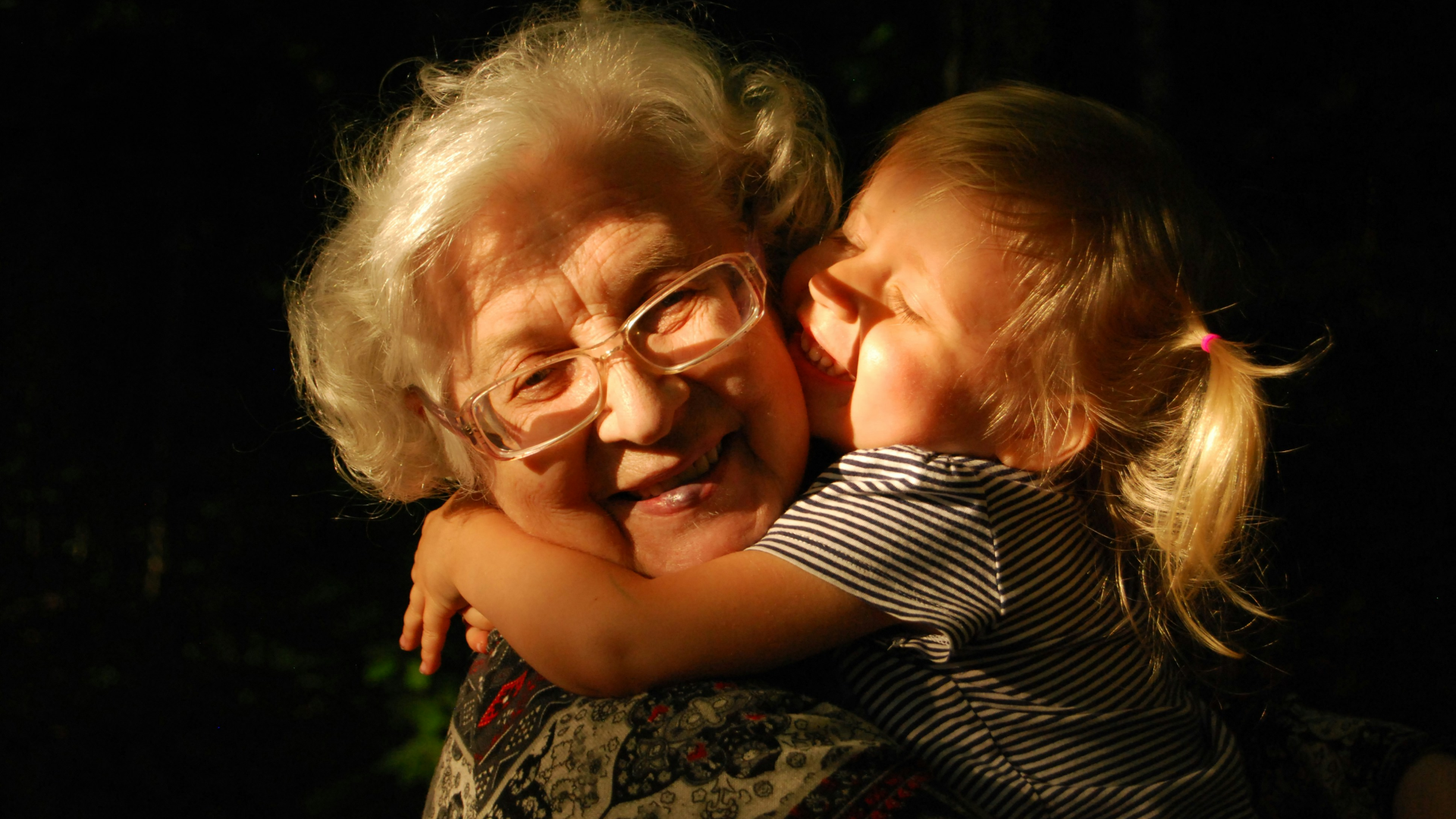 and elderly women hugging a young child