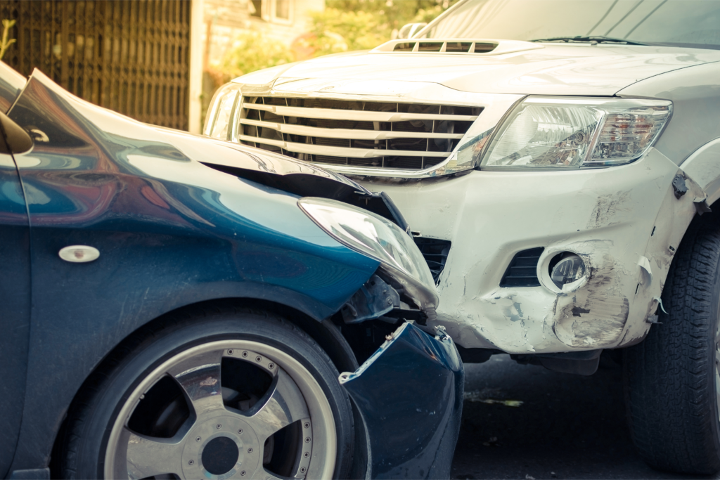 Head-on collision between a blue sedan and a white SUV showing significant damage