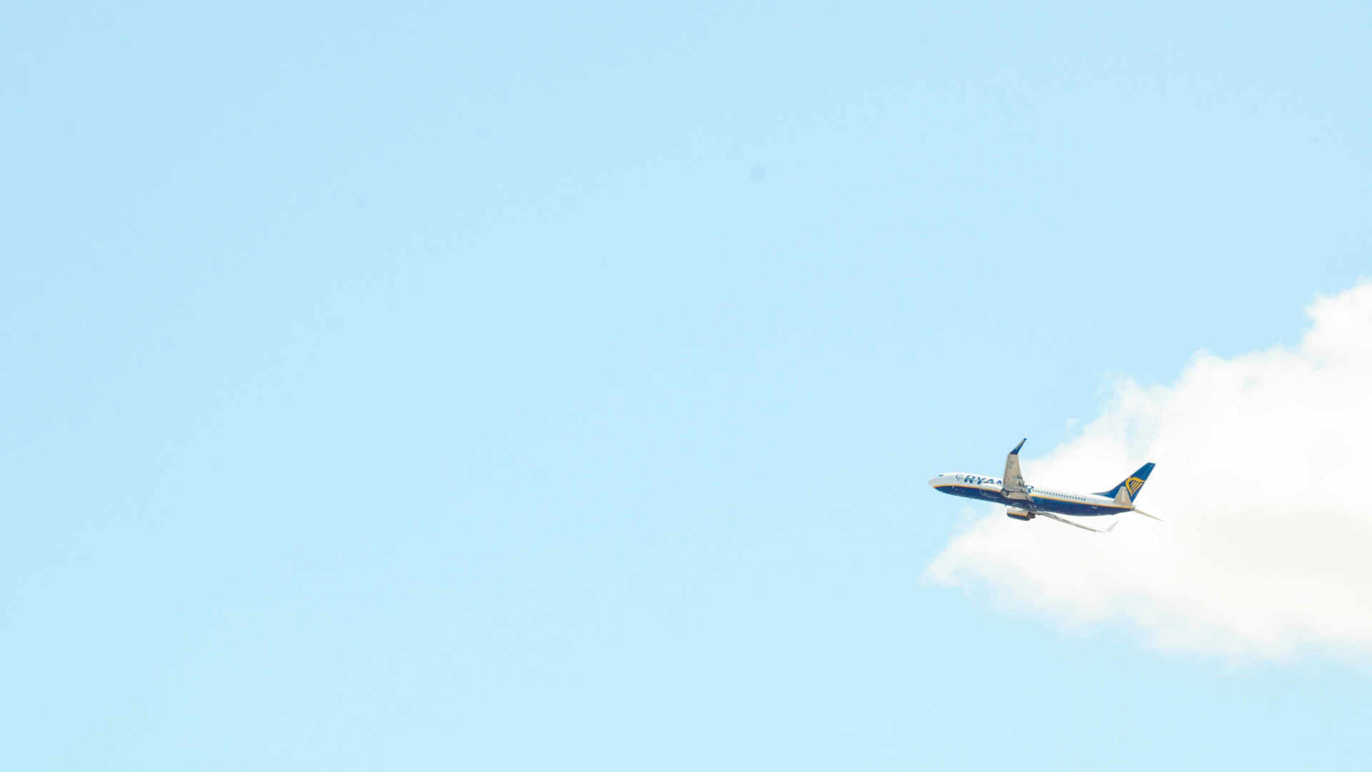 An air plane flying through a bright blue sky