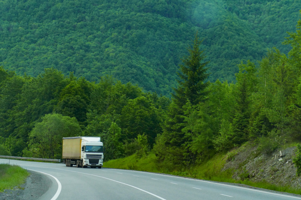 a old semi-truck driving on a highway
