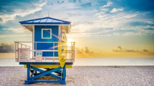 Blue lifeguard tower on a Florida beach with beach warning flag safety sign