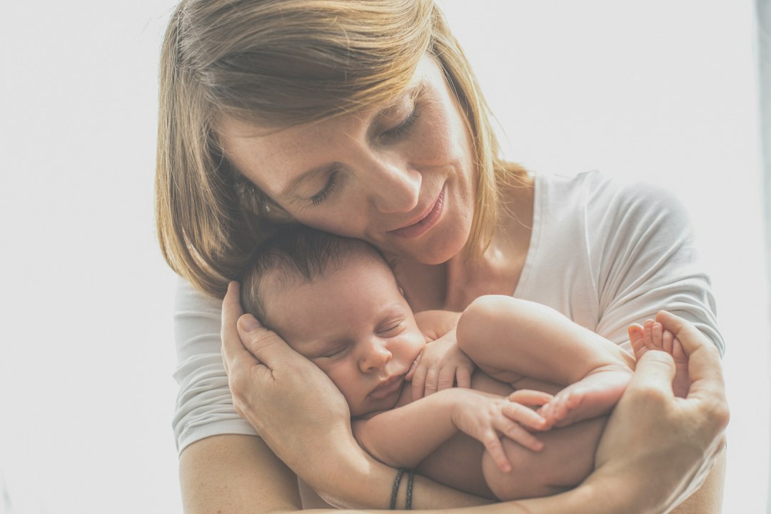 Una madre que sostiene con ternura a su bebé recién nacido