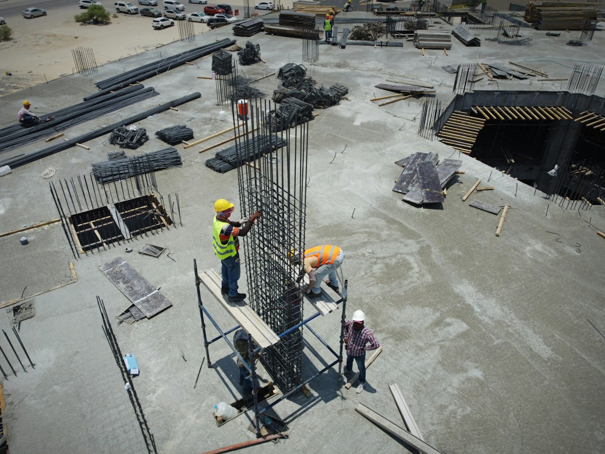 Construction workers assembling steel rebar on a large job site