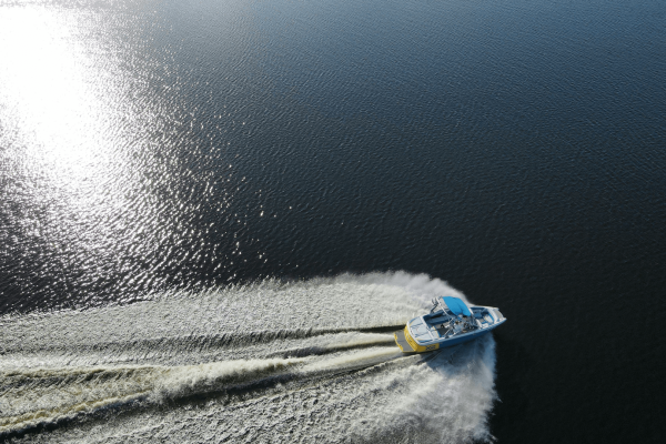 birds eye view of a boat small speed boat traveling across a body of water