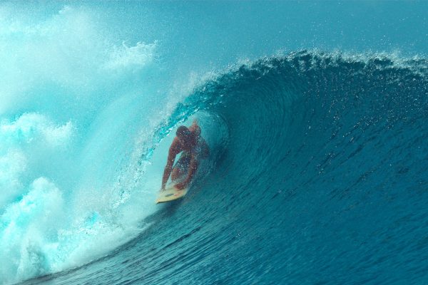 Surfer riding inside a large ocean wave