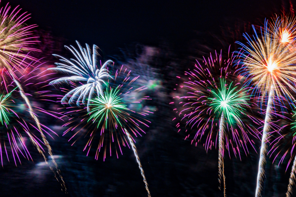 Colorful fireworks exploding in the night sky during a public celebration