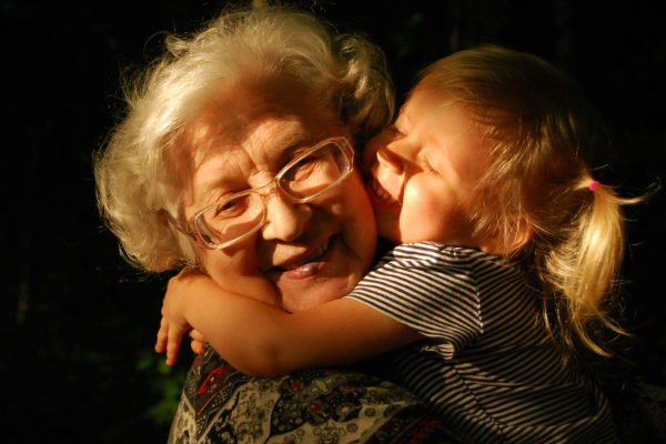 and elderly women hugging a young child