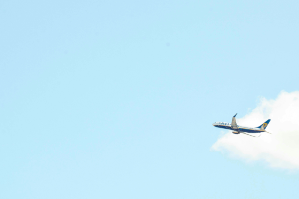 An air plane flying through a bright blue sky